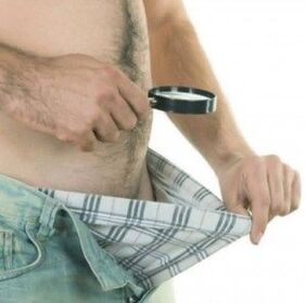 mężczyzna spogląda w dół swoich spodni i chce powiększyć penisa żelem